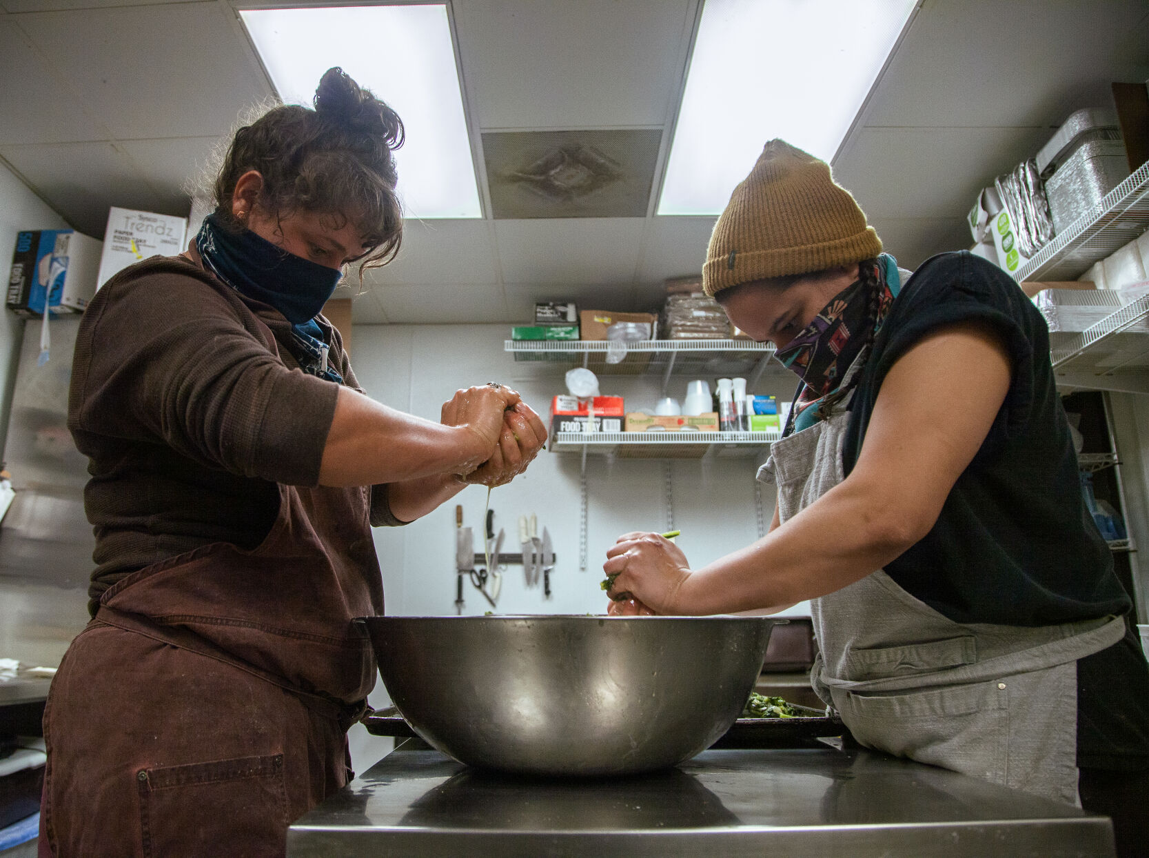 Michelle La Fata, left, and Malaika Kamau hand squeeze sauteed greens for their garlic and greens ravioli.